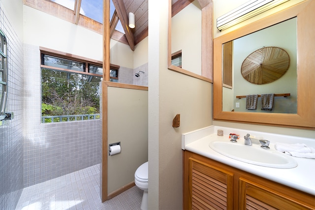 bathroom with tiled shower, tile patterned floors, vanity, and toilet