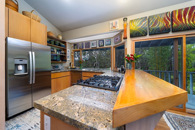 kitchen with light hardwood / wood-style floors, a healthy amount of sunlight, sink, kitchen peninsula, and stainless steel fridge with ice dispenser