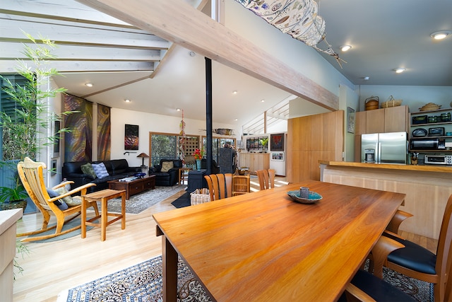 dining area with light hardwood / wood-style floors and lofted ceiling with beams