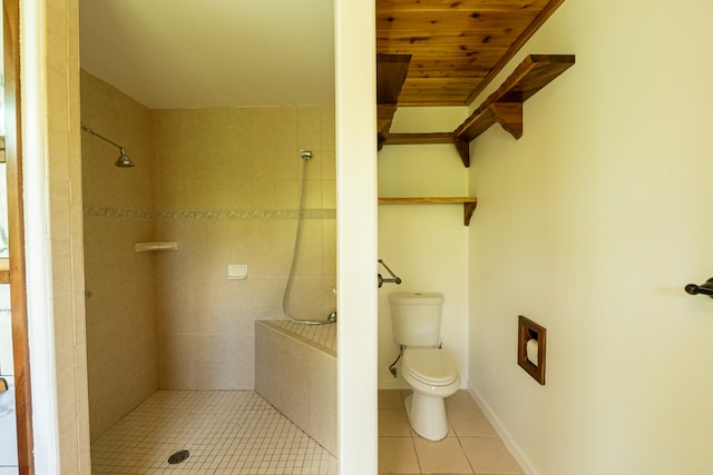 bathroom featuring tiled shower, toilet, and tile patterned floors