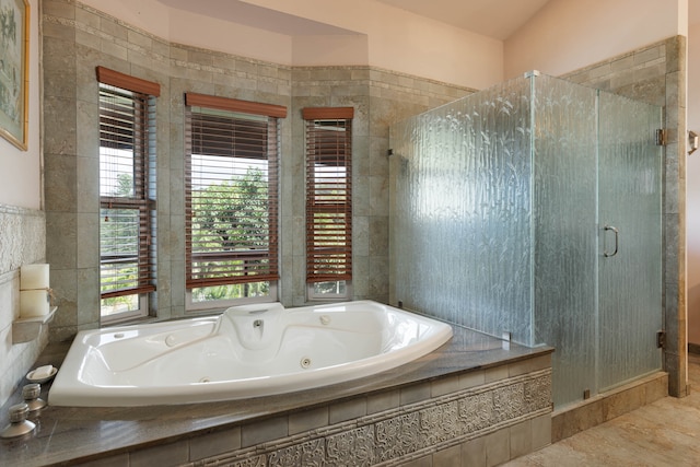 bathroom with tile walls, a wealth of natural light, tile patterned floors, and plus walk in shower