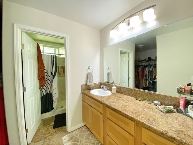 bathroom featuring walk in shower and vanity