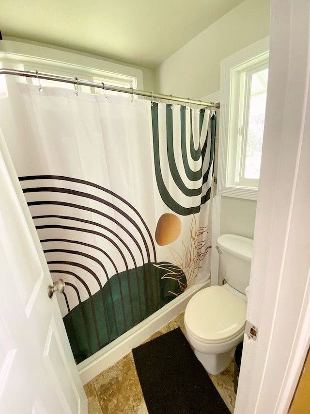 bathroom with toilet and a shower with shower curtain