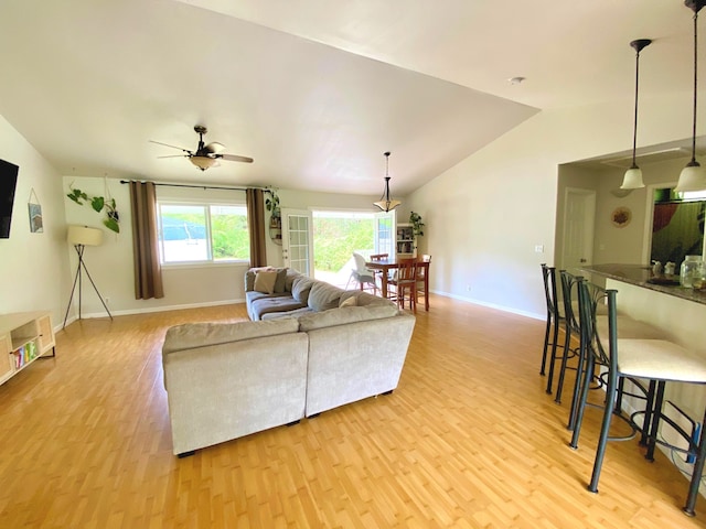 living room featuring ceiling fan, light hardwood / wood-style flooring, and lofted ceiling