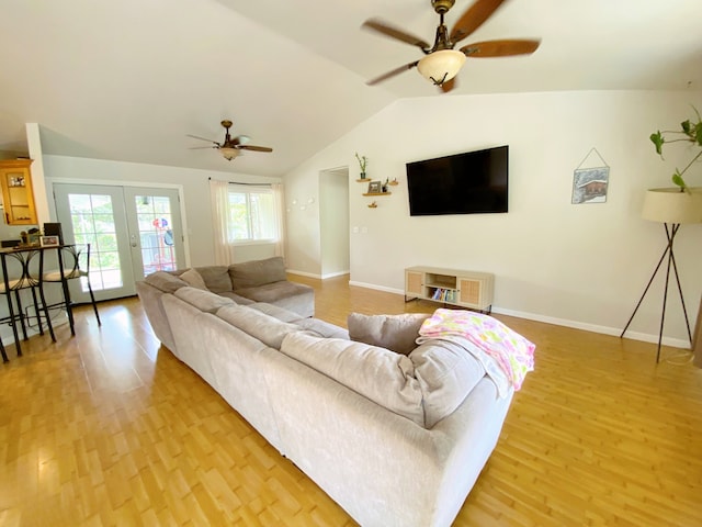 living room featuring light wood-type flooring, vaulted ceiling, ceiling fan, and french doors