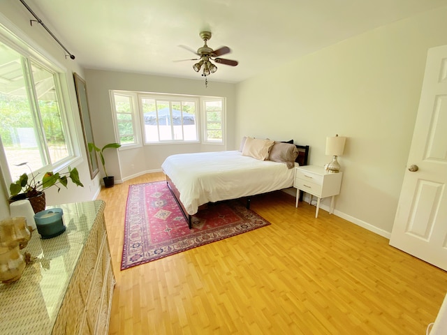 bedroom with light hardwood / wood-style floors and ceiling fan