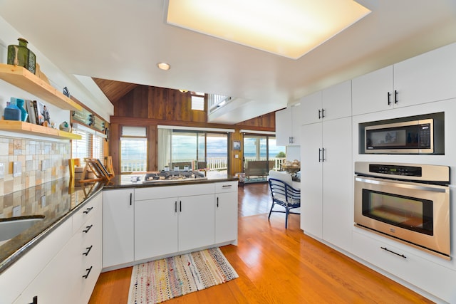 kitchen featuring white cabinets, light wood-type flooring, appliances with stainless steel finishes, and kitchen peninsula