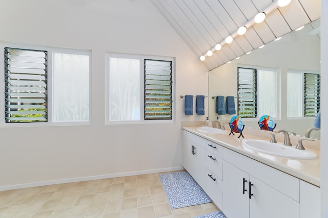 bathroom with tile patterned flooring, vanity, and vaulted ceiling