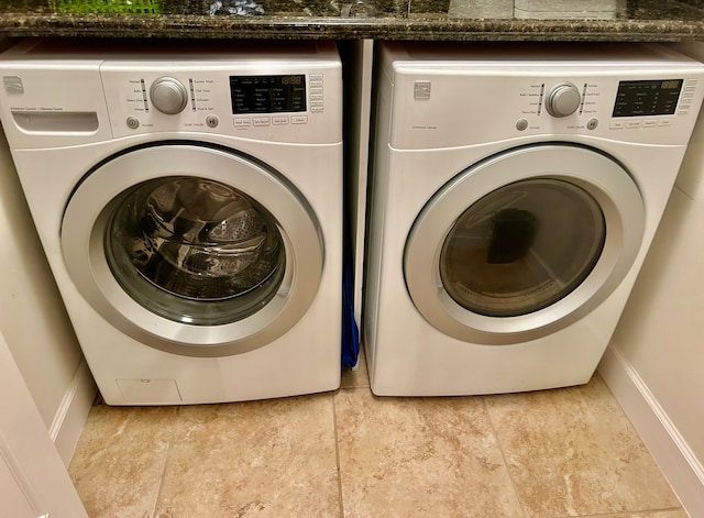 washroom featuring washer and clothes dryer and light tile patterned floors