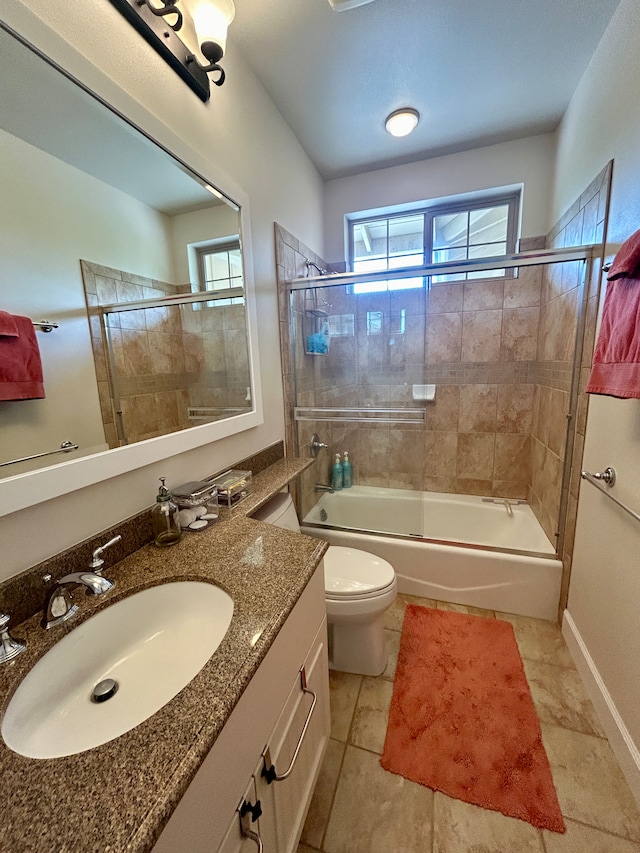 full bathroom featuring tile patterned flooring, combined bath / shower with glass door, vanity, and toilet