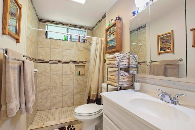 bathroom with tile patterned flooring, vanity, toilet, and curtained shower