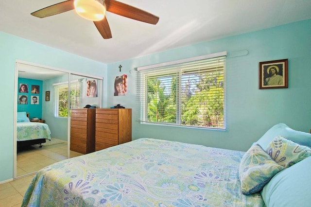 bedroom featuring multiple windows, ceiling fan, a closet, and light tile patterned floors