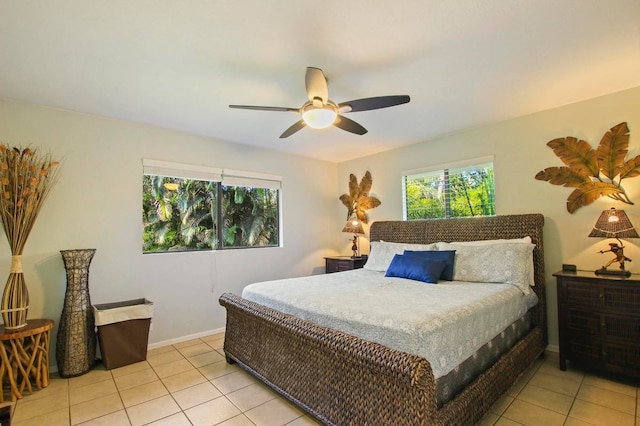 tiled bedroom featuring ceiling fan and multiple windows