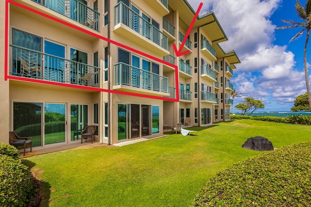 exterior space with a balcony and a lawn