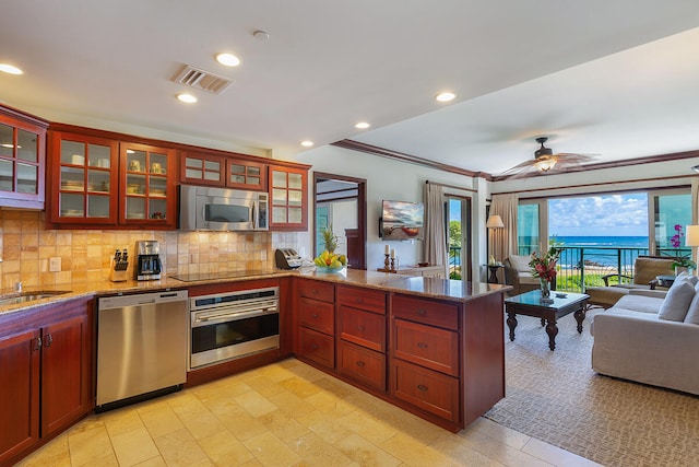 kitchen with ceiling fan, decorative backsplash, stainless steel appliances, kitchen peninsula, and crown molding