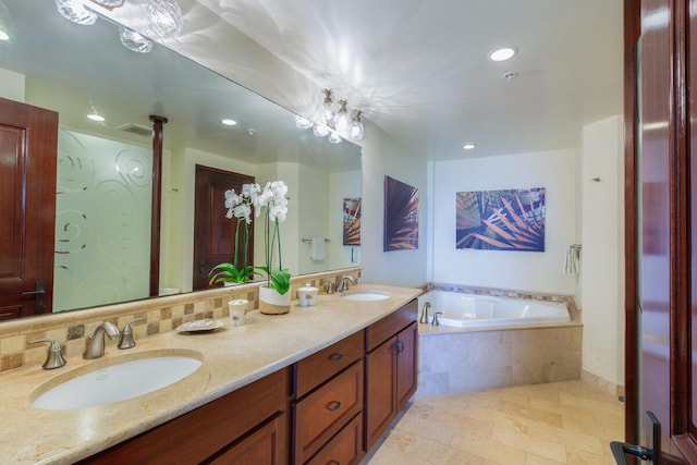 bathroom featuring a relaxing tiled tub and vanity