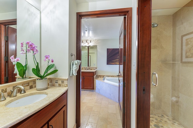 bathroom with vanity and shower with separate bathtub