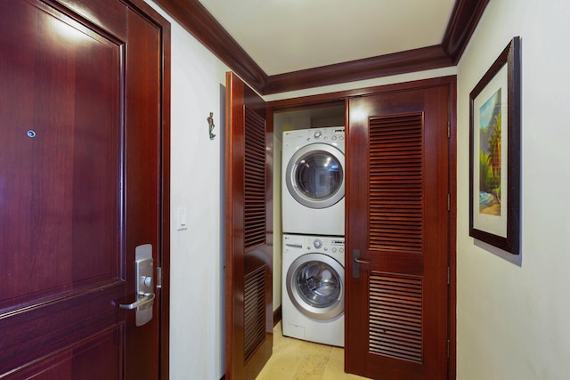 laundry area with crown molding and stacked washing maching and dryer