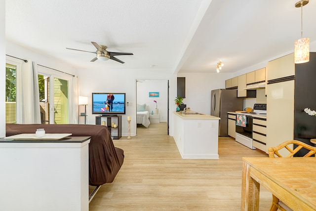 kitchen featuring light wood-type flooring, ceiling fan, stainless steel fridge, pendant lighting, and electric stove