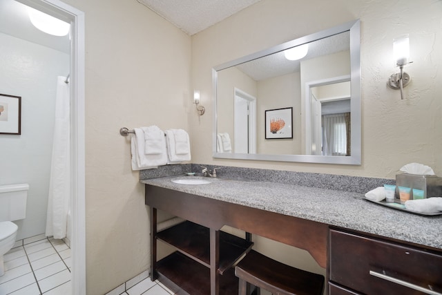 bathroom with vanity, a textured ceiling, toilet, and tile patterned floors