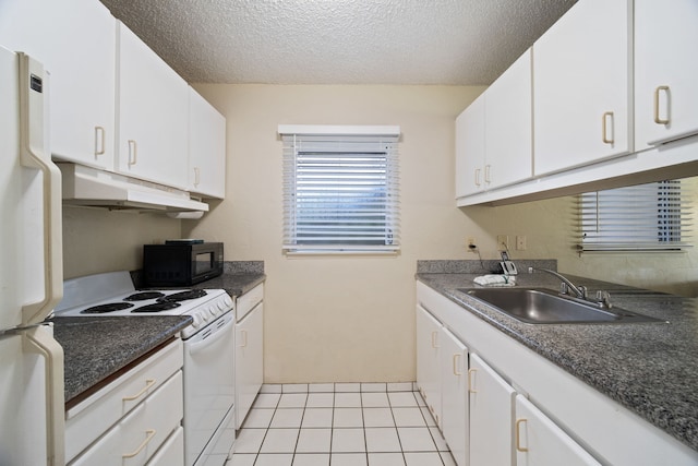 kitchen with white appliances, white cabinetry, and light tile patterned flooring