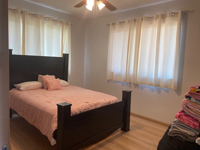 bedroom with multiple windows, light wood-type flooring, and ceiling fan