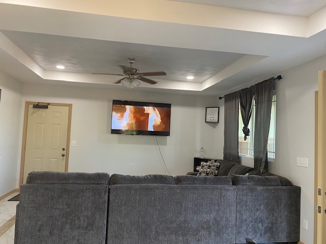 cinema featuring a tray ceiling and ceiling fan