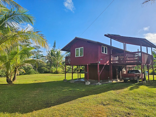 rear view of property featuring a yard and a wooden deck