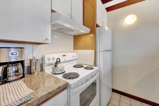 kitchen with tasteful backsplash, white appliances, light tile patterned flooring, and white cabinets