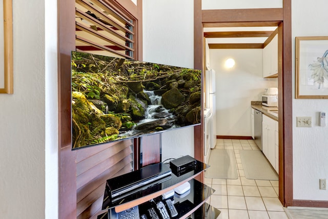 kitchen featuring light tile patterned flooring, dishwasher, and white cabinets