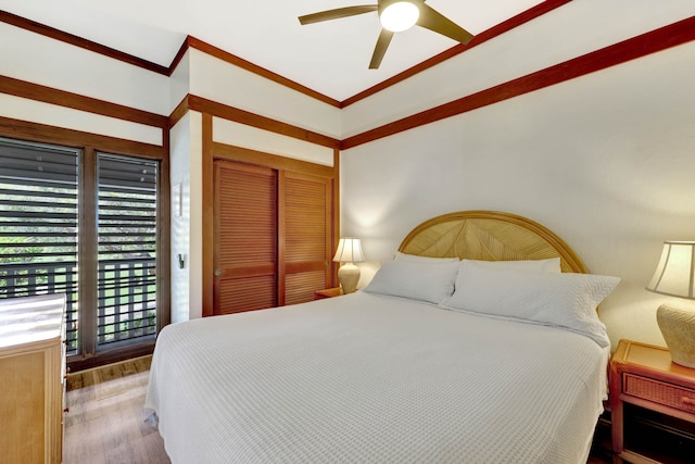 bedroom with a closet, hardwood / wood-style flooring, ornamental molding, and ceiling fan