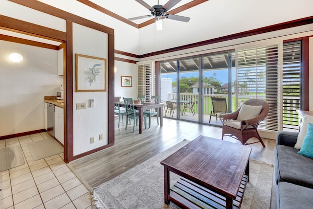 living room featuring ceiling fan, light hardwood / wood-style flooring, and a high ceiling