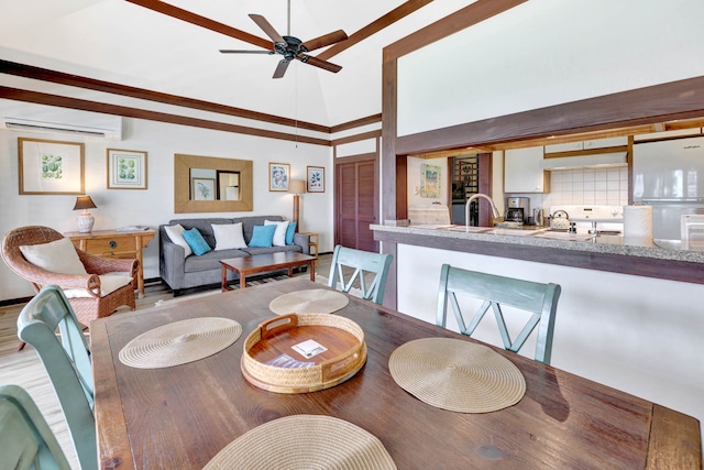 dining area with light hardwood / wood-style floors, a wall unit AC, ceiling fan, ornamental molding, and high vaulted ceiling