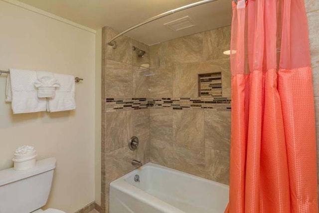 bathroom with toilet and shower / bath combo with shower curtain