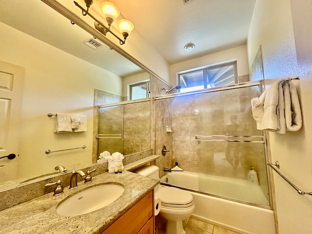 full bathroom with tile patterned floors, toilet, vanity, and combined bath / shower with glass door