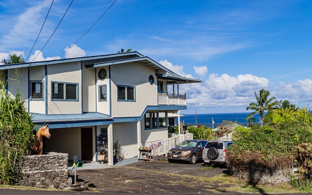 exterior space featuring a balcony and a water view