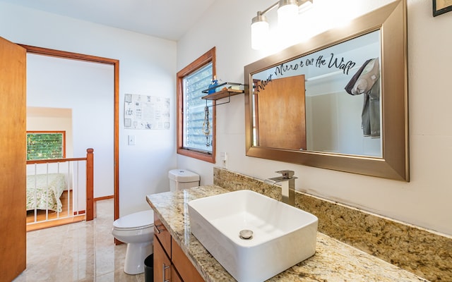 bathroom with tile patterned flooring, vanity, and toilet