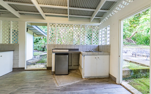 exterior space with stainless steel refrigerator, sink, and tasteful backsplash