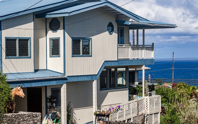 view of front of property with a balcony and a water view