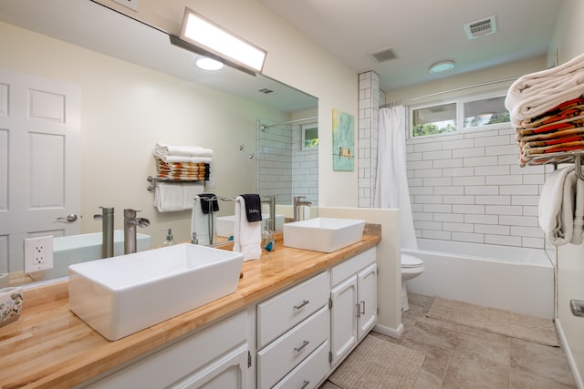 full bathroom with toilet, shower / bath combo with shower curtain, vanity, and tile patterned floors