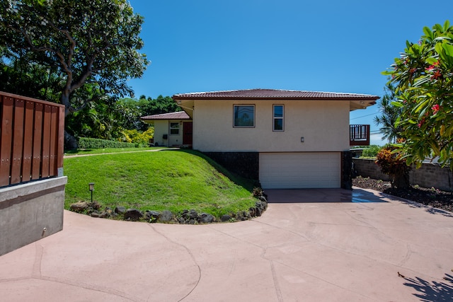 back of house with a garage and a lawn