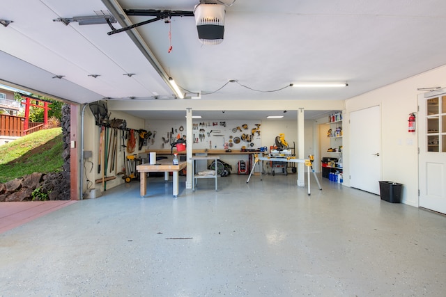 garage with a garage door opener and a workshop area