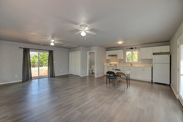 interior space with ceiling fan, light hardwood / wood-style flooring, white refrigerator, and white cabinets