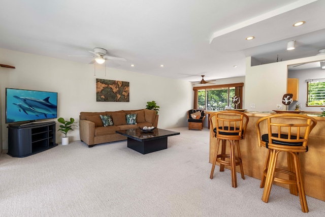 carpeted living room featuring bar, plenty of natural light, and ceiling fan