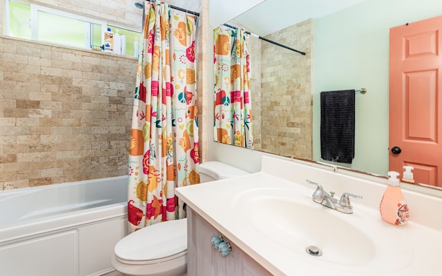 full bathroom featuring vanity, toilet, and shower / tub combo with curtain