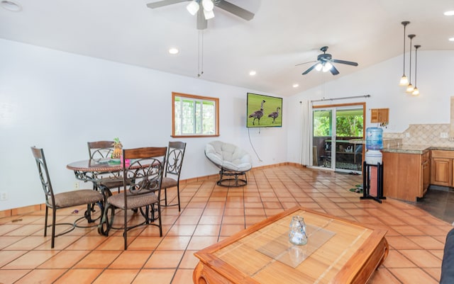 dining room featuring lofted ceiling, ceiling fan, and light tile patterned floors