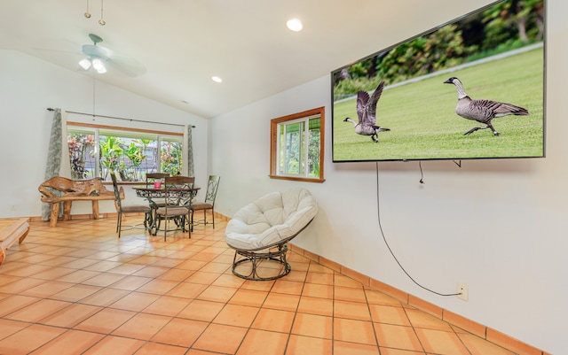 living area featuring ceiling fan, light tile patterned flooring, and lofted ceiling