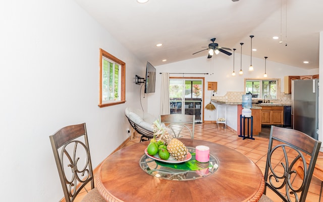 dining area with lofted ceiling, ceiling fan, sink, and light tile patterned floors