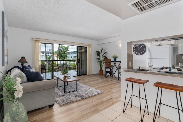 living room featuring a textured ceiling and light wood-type flooring