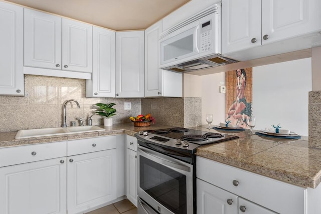 kitchen with sink, decorative backsplash, electric range, and white cabinets